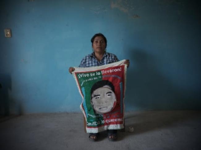 Cristina Bautista holds a half-knitted sign picturing her son Benjamín Ascencio Bautista, one of 43 students who vanished in Ayotzinapa.